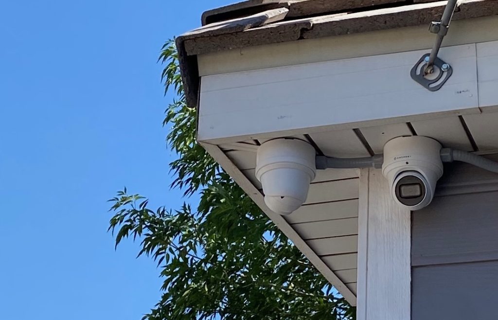 Photo of two Amcrest security cameras mounted under roof soffit